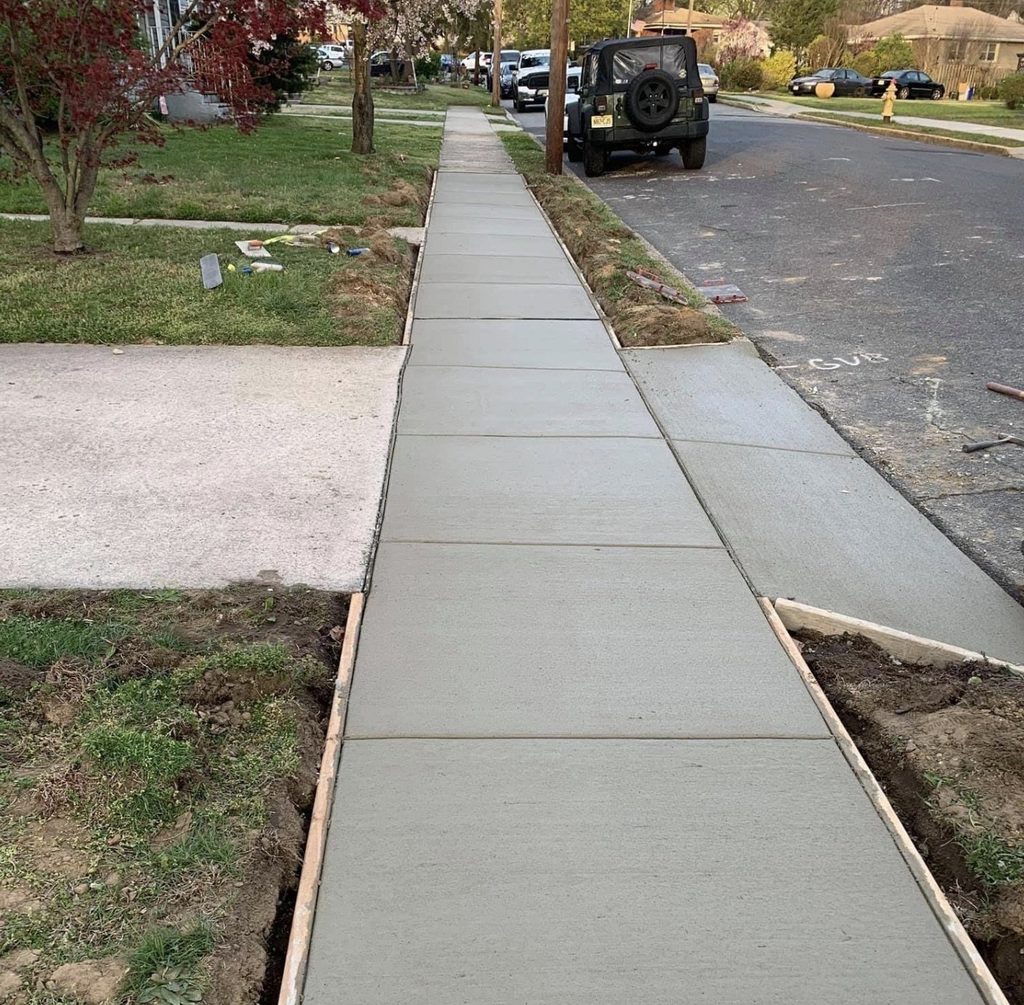 Concrete sidewalk running alongside a lawn